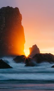 Preview wallpaper ocean, rock, sunset, rays, surf