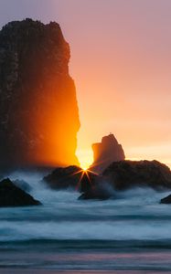 Preview wallpaper ocean, rock, sunset, rays, surf