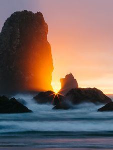 Preview wallpaper ocean, rock, sunset, rays, surf