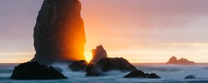 Preview wallpaper ocean, rock, sunset, rays, surf