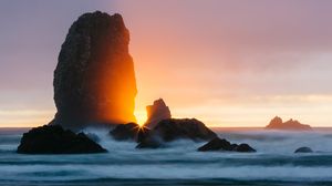 Preview wallpaper ocean, rock, sunset, rays, surf