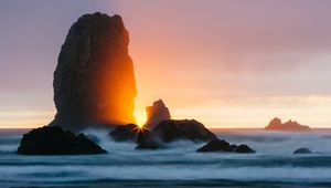 Preview wallpaper ocean, rock, sunset, rays, surf