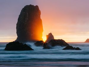 Preview wallpaper ocean, rock, sunset, rays, surf