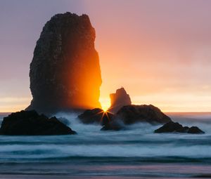 Preview wallpaper ocean, rock, sunset, rays, surf