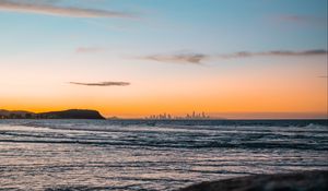 Preview wallpaper ocean, rocks, city, horizon