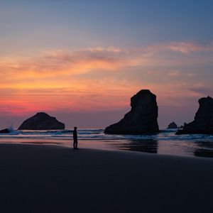 Preview wallpaper ocean, silhouette, sunset, rocks, loneliness