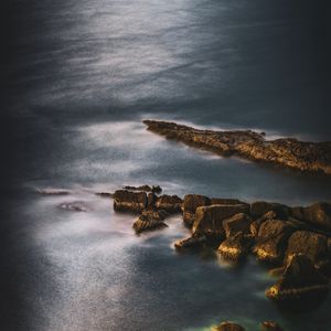 Preview wallpaper ocean, stones, surface, water, twilight