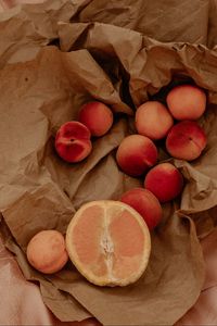 Preview wallpaper orange, nectarines, fruit, paper, crumpled