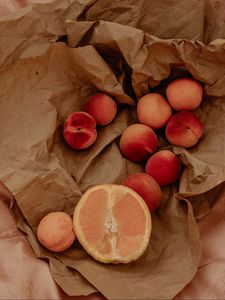 Preview wallpaper orange, nectarines, fruit, paper, crumpled