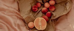 Preview wallpaper orange, nectarines, fruit, paper, crumpled