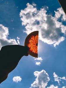Preview wallpaper orange, slice, hand, clouds, sky
