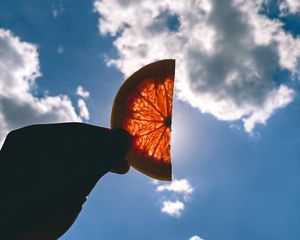 Preview wallpaper orange, slice, hand, clouds, sky