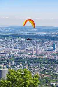 Preview wallpaper paraglider, city, buildings, flight, trees