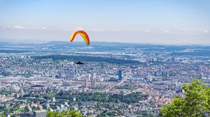 Preview wallpaper paraglider, city, buildings, flight, trees