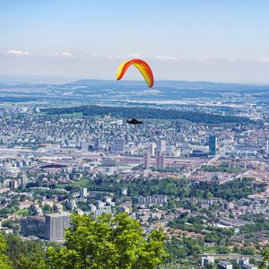 Preview wallpaper paraglider, city, buildings, flight, trees