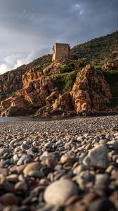 Preview wallpaper pebbles, rocks, sea, coast, building, nature