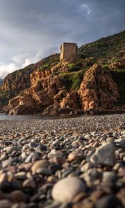 Preview wallpaper pebbles, rocks, sea, coast, building, nature