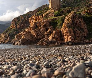 Preview wallpaper pebbles, rocks, sea, coast, building, nature