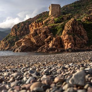 Preview wallpaper pebbles, rocks, sea, coast, building, nature