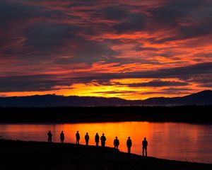 Preview wallpaper people, silhouettes, sunset, lake, mountains