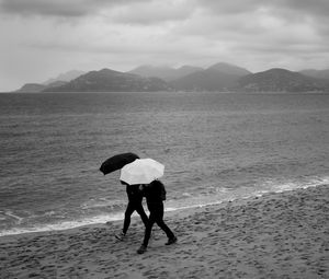 Preview wallpaper people, umbrellas, rain, sea, beach