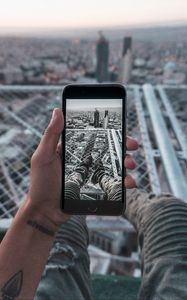 Preview wallpaper phone, hand, photo, roof, city, aerial view