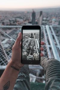 Preview wallpaper phone, hand, photo, roof, city, aerial view