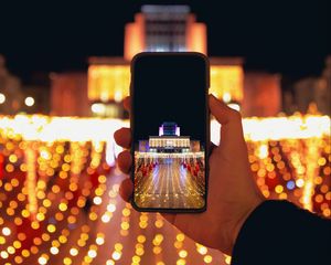 Preview wallpaper phone, hand, photo, building, garlands