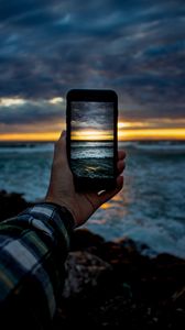 Preview wallpaper phone, hand, shooting, sunset, sea