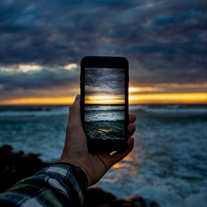 Preview wallpaper phone, hand, shooting, sunset, sea