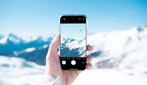 Preview wallpaper phone, hand, snapshot, mountains, snow, winter