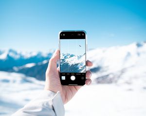 Preview wallpaper phone, hand, snapshot, mountains, snow, winter