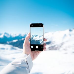 Preview wallpaper phone, hand, snapshot, mountains, snow, winter