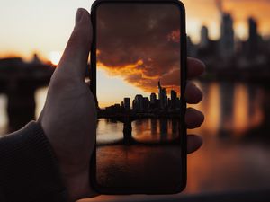 Preview wallpaper phone, snapshot, photo, hand, city, sunset