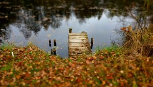 Preview wallpaper pier, autumn, river, fallen leaves