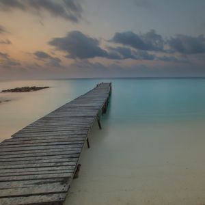 Preview wallpaper pier, coast, sand, horizon, clouds