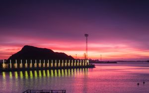 Preview wallpaper pier, coast, sunset, mountains, glow