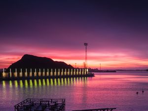 Preview wallpaper pier, coast, sunset, mountains, glow