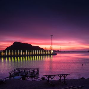 Preview wallpaper pier, coast, sunset, mountains, glow