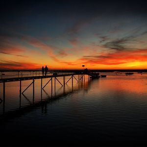 Preview wallpaper pier, couple, silhouettes, sea, evening