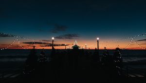 Preview wallpaper pier, dark, garlands, lights, silhouettes