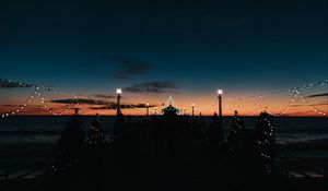 Preview wallpaper pier, dark, garlands, lights, silhouettes