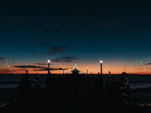 Preview wallpaper pier, dark, garlands, lights, silhouettes