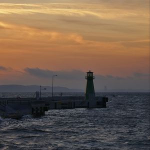Preview wallpaper pier, lighthouse, sea, waves, sunset