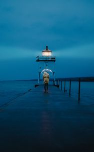 Preview wallpaper pier, man, lighthouse, umbrella, sea, twilight