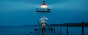 Preview wallpaper pier, man, lighthouse, umbrella, sea, twilight