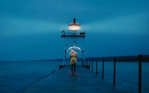 Preview wallpaper pier, man, lighthouse, umbrella, sea, twilight