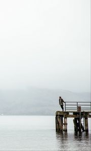 Preview wallpaper pier, man, loneliness, melancholia, lake, fog, water