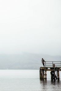 Preview wallpaper pier, man, loneliness, melancholia, lake, fog, water