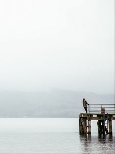 Preview wallpaper pier, man, loneliness, melancholia, lake, fog, water